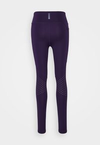 Fialové legíny s vysokým pasem, které mají perforované detaily na dolní části nohou a hladký, pružný materiál pro pohodlí.