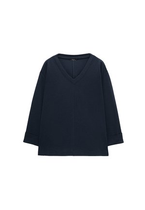 Granatowy, długi top z dekoltem w serek, z mankietami na rękawach i prostym dołem, prezentowany na białym tle.