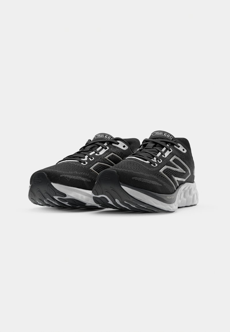 Zapatillas deportivas negras con parte superior de malla, acentos reflectantes y una entresuela blanca acolchada. Incluye una suela exterior texturizada para mayor tracción.