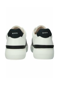 Białe skórzane sneakersy z czarnymi akcentami, teksturowanym obcasem i logiem "BLCKSTN" z tyłu. Okrągły kształt z wyściełanym kołnierzem.