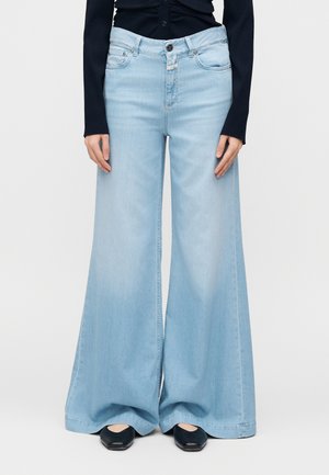 Jean large en denim bleu clair, avec une taille haute, une fermeture par boutons et deux poches avant, avec une texture lisse et une coupe ample.