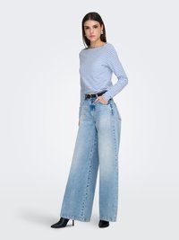 Langærmet trøje med striber i hvid og blå, kombineret med højtaljede, lyseblå jeans med brede ben. Sort bælte og spidse, sorte hæle.