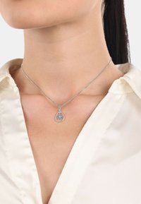 Sterling silverhalsband med en droppformad hänge som har en blå ädelstensblommönster, hängande från en tunn, glänsande kedja.