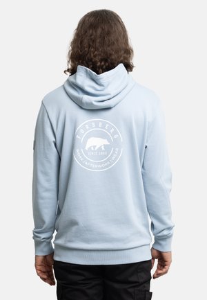 Light blue hoodie with a drawstring hood, ribbed cuffs, and a large white circular graphic on the back featuring a bear and text.