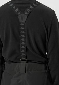 Zwarte fleece top met zwarte verstelbare bretels met een herhaald logo ontwerp. Gladde textuur en praktische pasvorm voor actief gebruik.