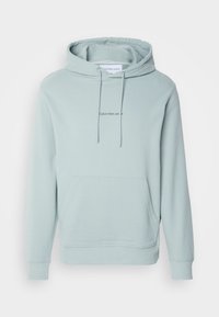 Felpa blu chiaro realizzata in morbido cotone, con tasca frontale, polsini a costine e un piccolo logo sul petto. Cappuccio con lacci regolabili.
