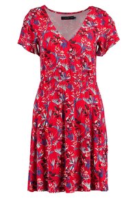 Czerwona sukienka w kwiaty z krótkimi rękawami, dekoltem w serek, elastycznym paskiem i rozkloszowaną spódnicą. Zawiera białe i niebieskie wzory kwiatowe na całej powierzchni.