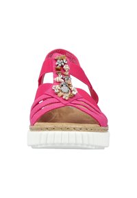 Roze sandalen met gekruiste banden en decoratieve versieringen, voorzien van een beige binnenzool en een witte rubberen zool met textuurdetails.