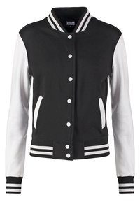 Veste universitaire noire et blanche avec fermeture à pression, col, poignets et ourlet rayés, manches blanches et bordure de poche blanche.