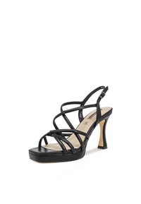 Sandal nero con tacco alto, dotato di cinturini incrociati, punta rotonda e base a piattaforma. Texture in pelle liscia e tacco affusolato.