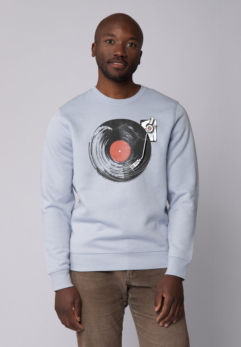 Lichtblauwe sweatshirt met een zwart vinylplaat grafiek met een rode center en draaitafel, tegen een grijze achtergrond.