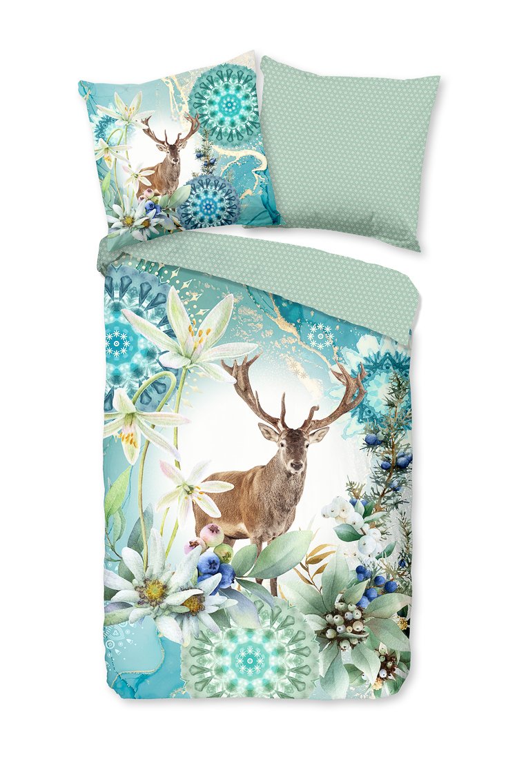 Dekbedovertrekset met een teal achtergrond, bloemen- en geometrische patronen, een hertillustratie en een effen groene kussensloop met kleine stippen.