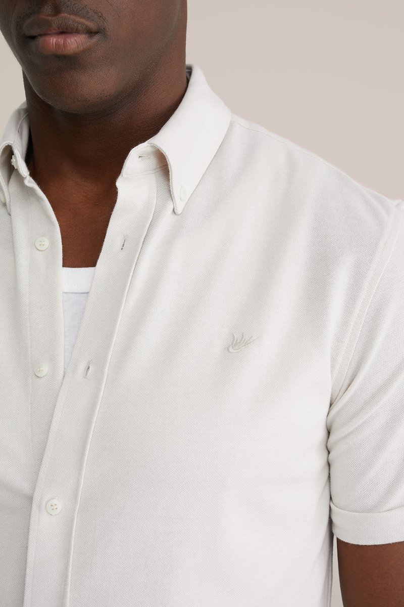 Korte mouwen, lichtbeige shirt met kraag in gestructureerde stof, voorzien van een subtiel geborduurd logo en knoopsluiting.