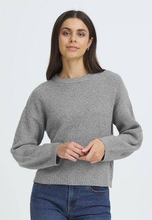 Grå strikket sweater med ribbede detaljer, rund halsudskæring og brede ærmer. Kombineret med blå denim for et afslappet look.