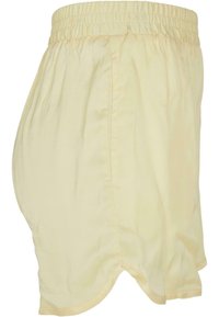 Helle gelbe, elastische Shorts mit einem lockeren Sitz. Verfügt über Seitentaschen und ein abgerundetes Saumdesign für Komfort und Bewegungsfreiheit.