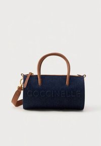 Blauwe denim handtas met bruine leren accenten, bovenhandvatten en een afneembare riem. Voorzien van een gegraveerde merknaam aan de voorkant.