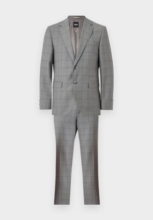 Grauer Zweiknopf-Anzug mit Reverskragen, Pattentaschen und passenden Hosen, vor weißem Hintergrund dargestellt.