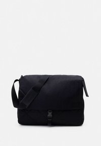 Fekete postás táska kárpitozott textúrával, állítható vállpánttal és elülső csattos záródással. Fedéllel ellátott kialakítás.