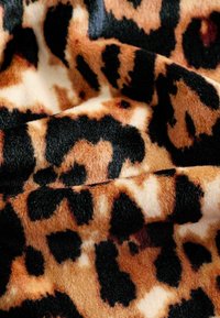 Leopardimustriga kangas pehme ja luksusliku tekstuuriga. Omab sooje pruunikaid ja beeže toone mustade laikudega heledal beežil taustal.