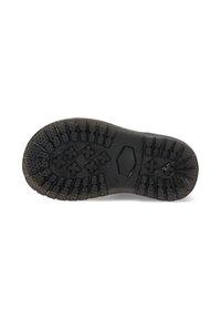 Suela de zapato de goma negra con un patrón de textura, que presenta diseños de agarre hexagonales y en forma de cruz. Construcción plana y sólida.