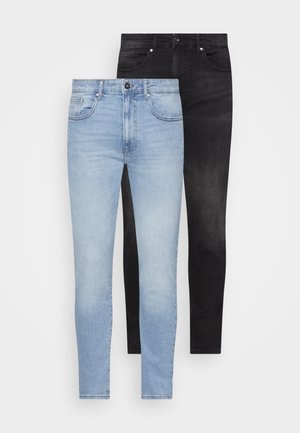 To par med tettsittende jeans: en lyseblå med en falmet finish, den andre helsvart. Begge har tradisjonelle lommer og metallbeslag.