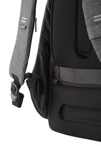 Zaino in tessuto grigio con retro in rete nera testurizzata, zip laterali, tracolla regolabile con fibbia e due linee grigie di accento.