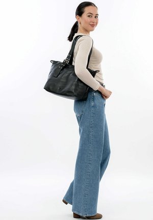 Black leather tote bag with a structured shape, featuring wide straps and silver hardware accents. Smooth texture, minimal branding visible.