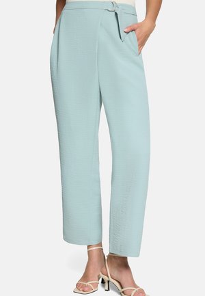 Hellblaue, strukturierte, hoch taillierte Hose mit Gürtel und silberner Schnalle, Seitentaschen, kombiniert mit beigen, Riemchen-Pumps mit Absatz.