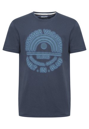 Tumed sinine puuvillane T-särk ümmarguse kaelusega ja lühikeste varrukatega. Ees on kiri "SUVEPUHKUS" ning helesinise trükiga vikerkaare graafika.