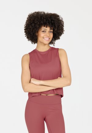 Mouwloze, cropped sporttop van diep rozenkleurige stof, gecombineerd met bijpassende fitted leggings. Soepele textuur, minimale naden, relaxed fit.