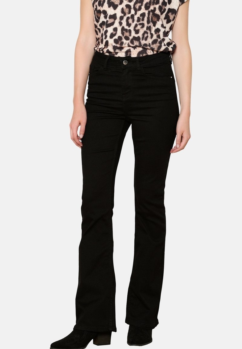 Černé zvonové džíny vyrobené z denimu, s klasickým pětipocket designem a středním páskem, stylizované s topem s leopardím potiskem.