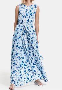 Maxi šaty z lehkého materiálu s modro-bílým abstraktním vzorem. Bezramenný design s vázáním v pase a splývavou sukní.