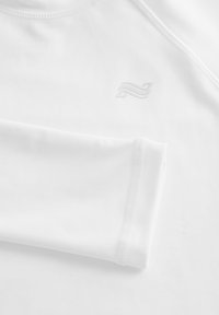 Maglia sportiva bianca a maniche lunghe realizzata in tessuto liscio. Presenta una scollatura rotonda, cuciture piatte e un logo discreto impresso sul petto.