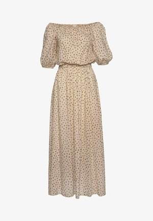 Beżowa sukienka maxi z odkrytymi ramionami, bufkami na rękawach, elastyczną talią oraz brązowym, nieregularnym wzorem w groszki na całej powierzchni.