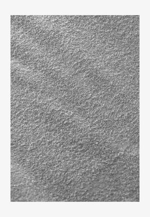 Szara teksturowana powierzchnia o włóknistej strukturze, cechująca się miękką i lekko nierówną fakturą oraz subtelnymi różnicami w odcieniach.