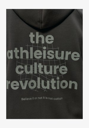 Černá mikina s kapucí a měkkou texturou, na které je velkým šedým písmem nápis: "revoluce v kultuře athleisure" a menší text níže: "Věřte nebo ne, není to bavlna."