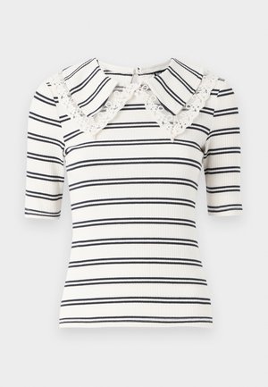Stripet t-skjorte med korte ermer i hvit og marineblå, med en oversized krage med blonder og ribbestruktur. Glidelås bak i nakken.