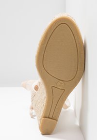 Basket beige tissée avec tige texturée, sangle de cheville rembourrée et semelle en caoutchouc dotée d'un motif antidérapant. Taille marquée 37 sur la semelle.