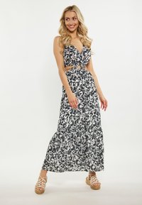 Rochie maxi cu imprimeu floral în alb și negru, cu decolteu adânc în V, talie cu decupaj și accent cu cerc, și fusta în straturi. Purtați-o cu espadrile cu bretele.