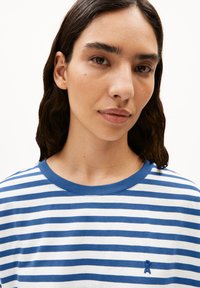 Striped t-shirt in blue and white, featuring a crew neckline and a small embroidered logo detail on the left side. Soft cotton material.