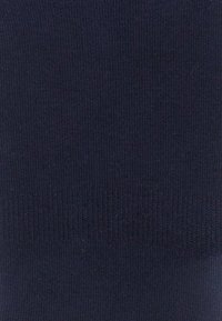 Marineblaue Strickware mit glatter Textur, die oben ein geripptes Design aufweist und ein einheitliches Muster auf der gesamten Fläche zeigt.