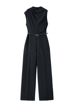 Combinaison noire sans manches avec col montant, pantalon à jambes larges et une fine ceinture noire avec boucle dorée à la taille.