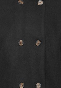 Manteau en tissu noir avec six boutons ronds mêlant des accents marron et transparents, présentant une texture douce et un design croisé.