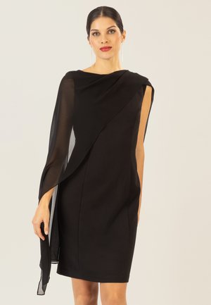 Schwarzes Kleid mit asymmetrischem Design, das auf einer Seite mit einem transparenten, drapierten Überzug ausgestattet ist, der einen Kontrast in der Textur und Silhouette schafft.
