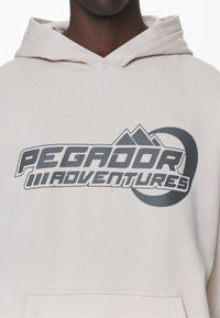 Pegador Jersey con capucha - sand