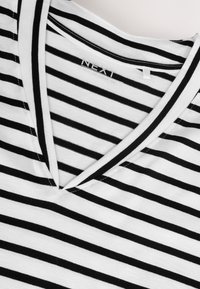 Svartvitrandig v-ringad t-shirt i mjukt tyg. Har smala ränder och en sydd halslinning. Märkesetikett: NEXT.