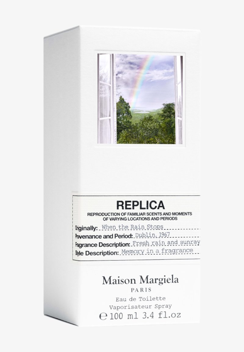 Maison Margiela Replica fragrance box with open window showing trees and rainbow, labeled "When the Rain Stops," 100ml Eau de Toilette spray.