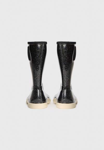 Bottes de pluie en caoutchouc pailletées noires avec des semelles beiges, vues de l'arrière sur un fond blanc.