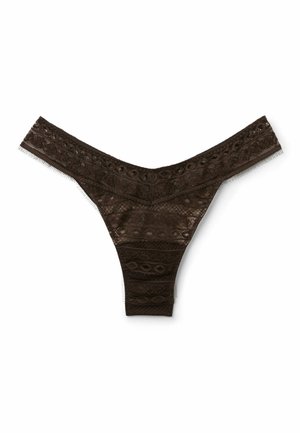 String en dentelle noire avec des motifs floraux et circulaires complexes, taille basse et tissu en mesh transparent, posé à plat sur un fond blanc.