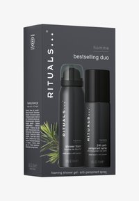 Emballage en boîte noire présentant un seul flacon de mousse de douche noire avec un capuchon transparent et un spray anti-transpirant noir, tous deux étiquetés "homme".